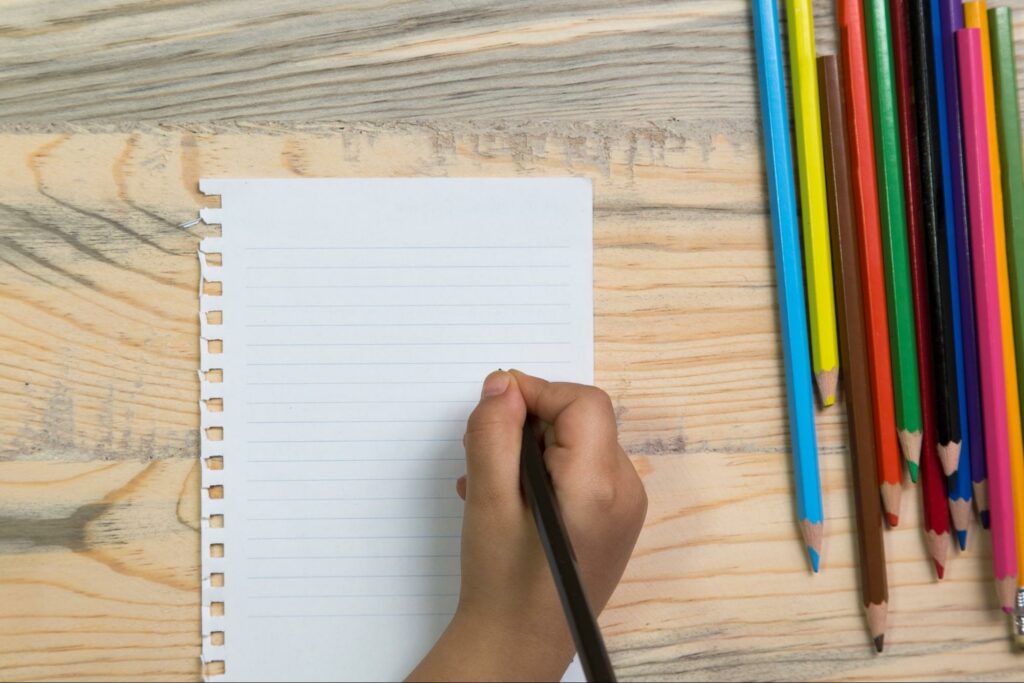 A child getting ready to journal with colored pencils.