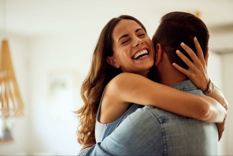 A happy couple embracing and smiling, showing the love, trust, and emotional connection in a monogamous relationship.
